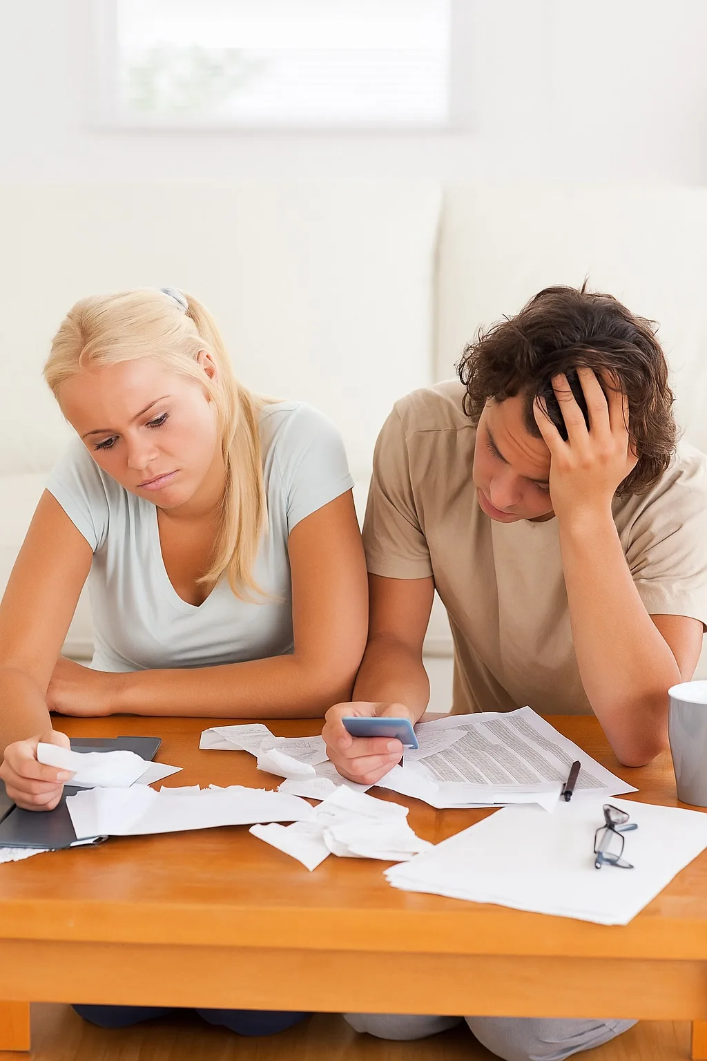 Stressed couple reviewing bills and credit cards, seeking Debt Consolidation & Refinance solutions